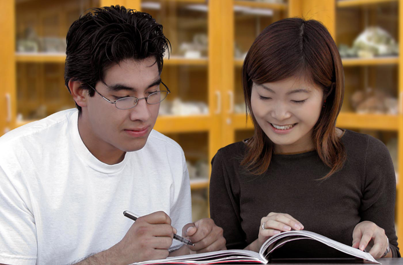 Students sharing a book in lab