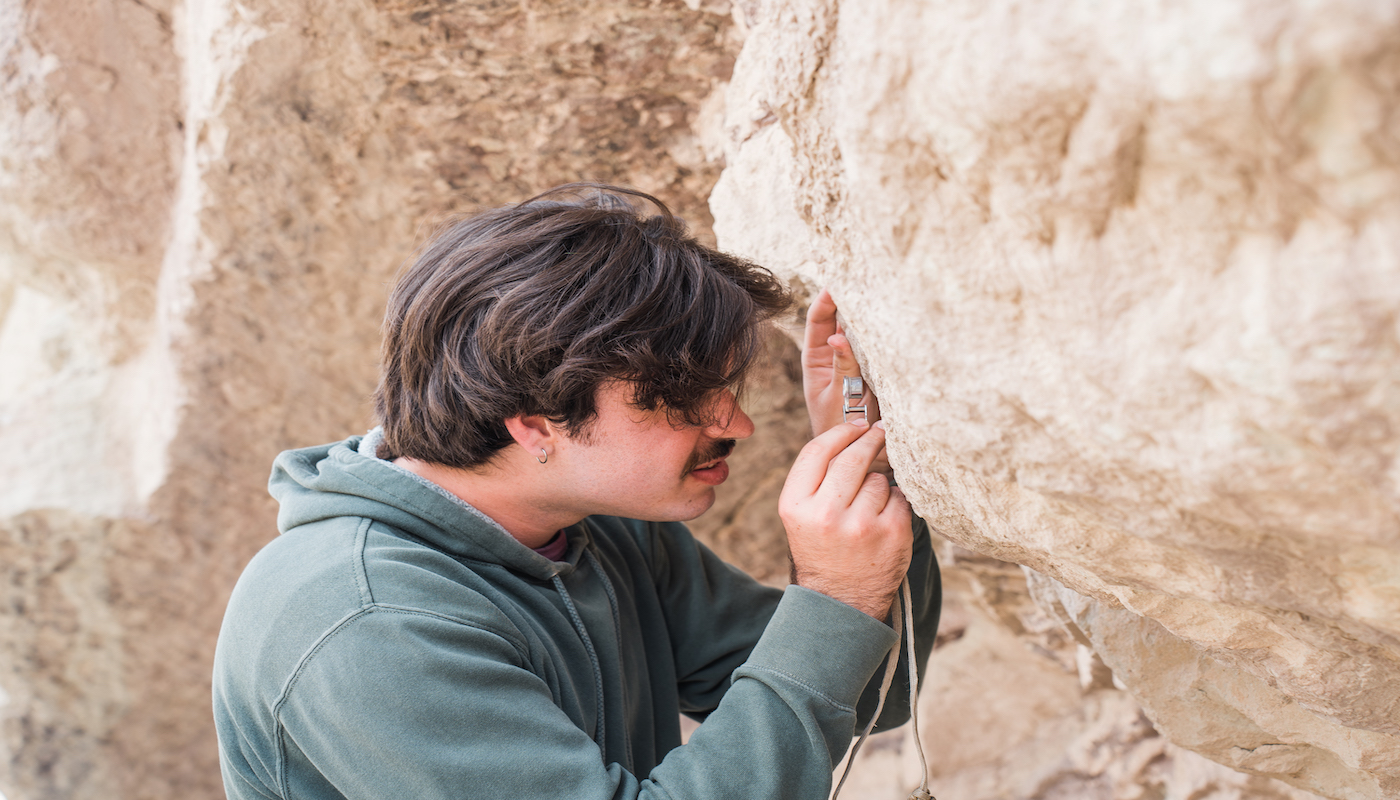 student examining rock face